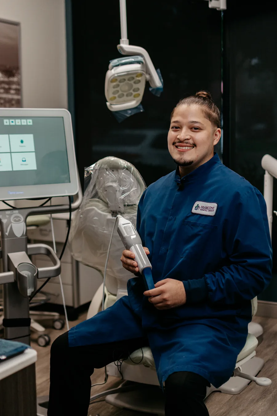 A dental assistant with the iTero scanner in a treatment room at Marconi Dental Group